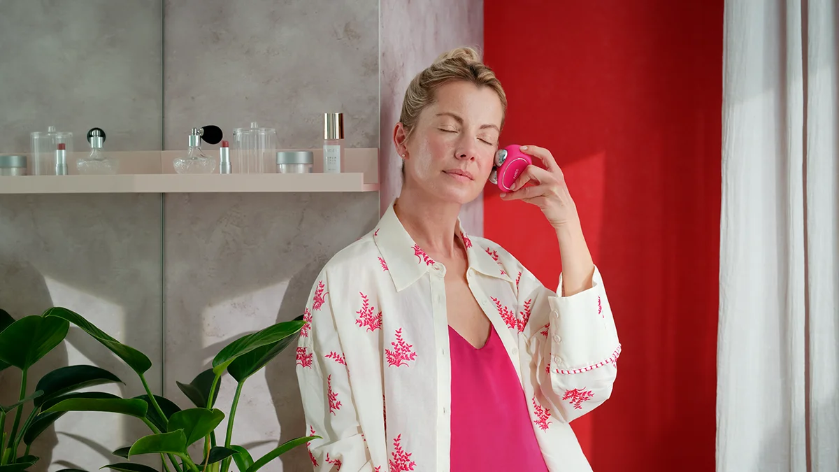 A woman doing a pleasant, anti-aging microcurrent facial at home